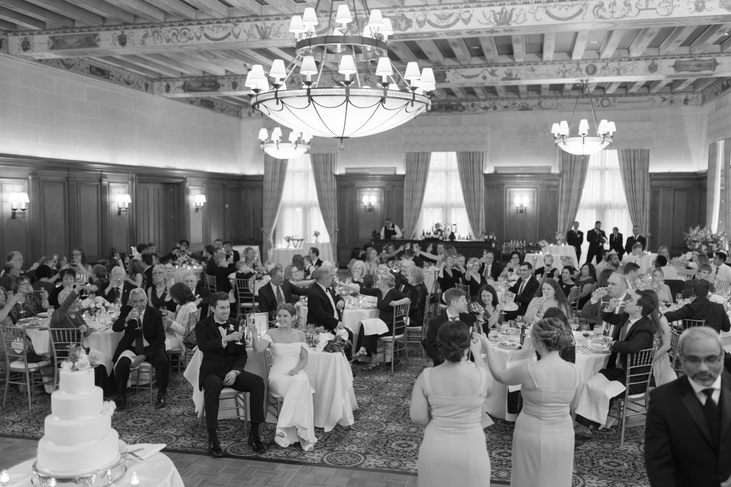 A couple raises their glasses during toasts at the Detroit Athletic Club wedding.