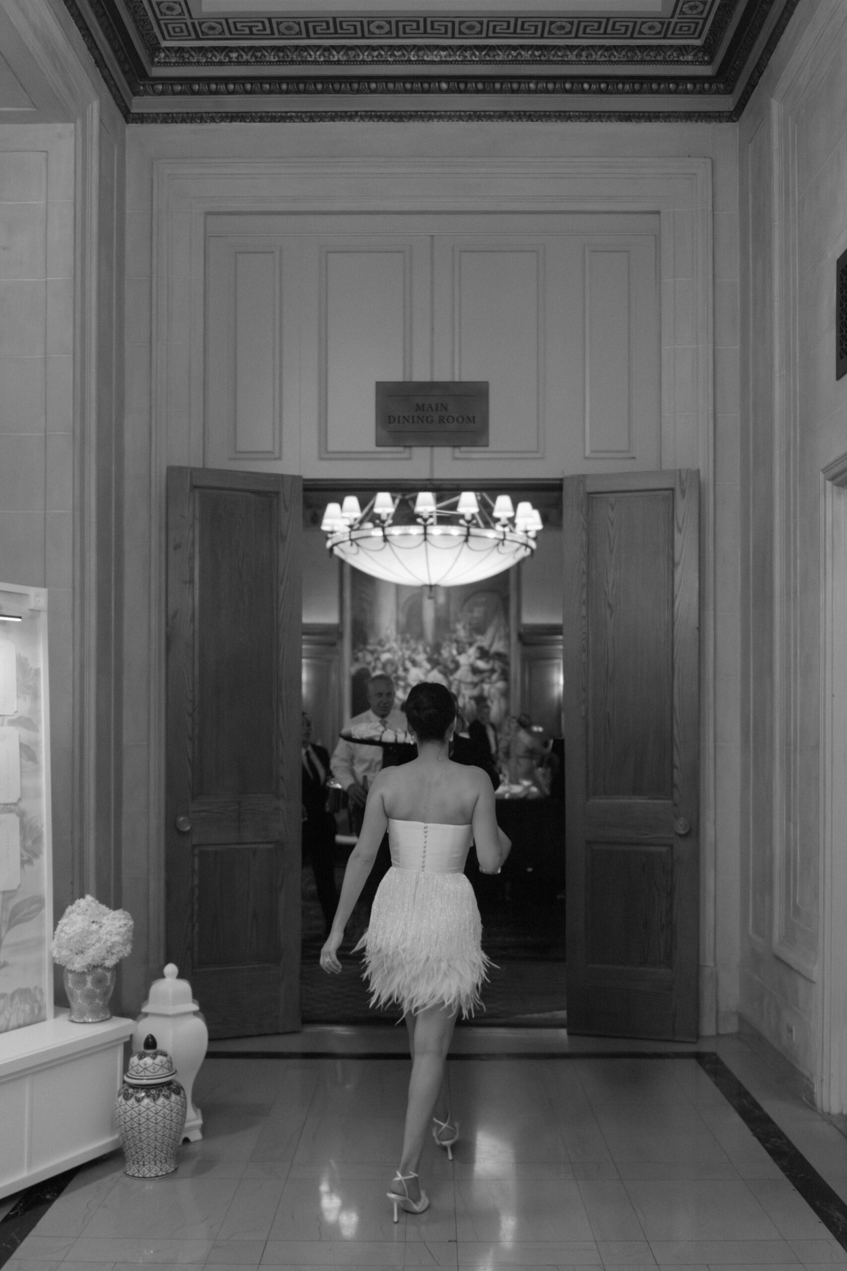 Bride walking into her reception in the ballroom of the Detroit Athletic Club after changing into her reception look.