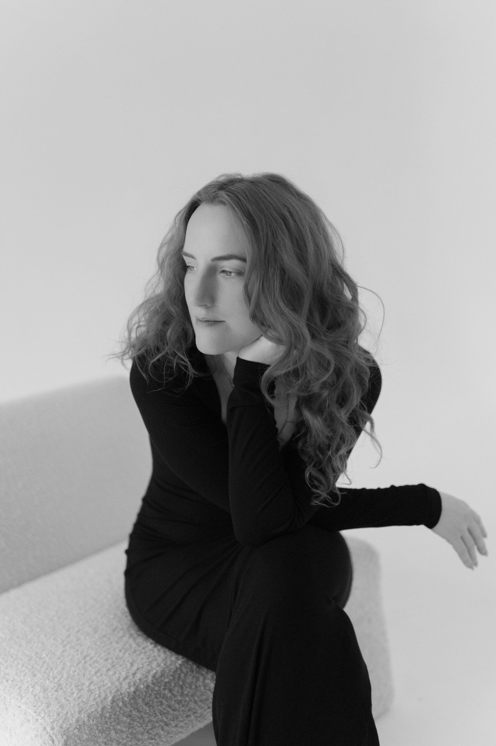 A portrait of Detroit wedding photographer Heather Jowett photographed in a studio on a white back drop.