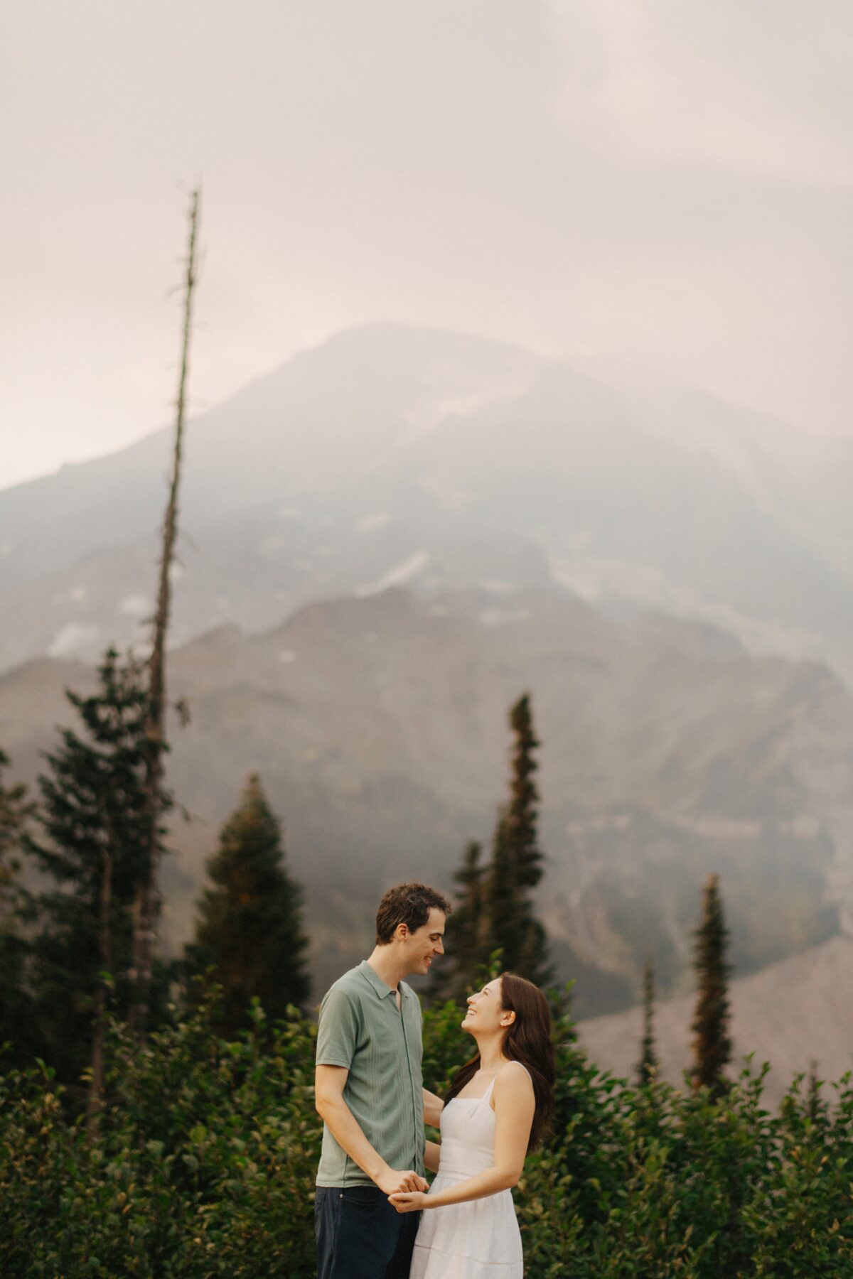 A couple in front of Mount Rainier on a foggy day.